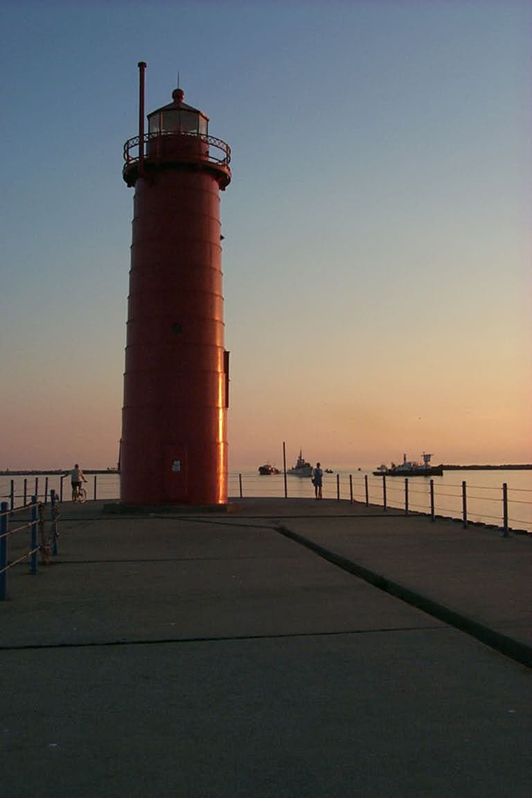 The Muskegon pierhead light silhouetted against an orange Lake Michigan sunset